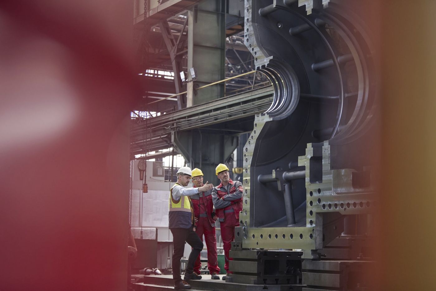 Engineers surveying machinery in an industrial hall